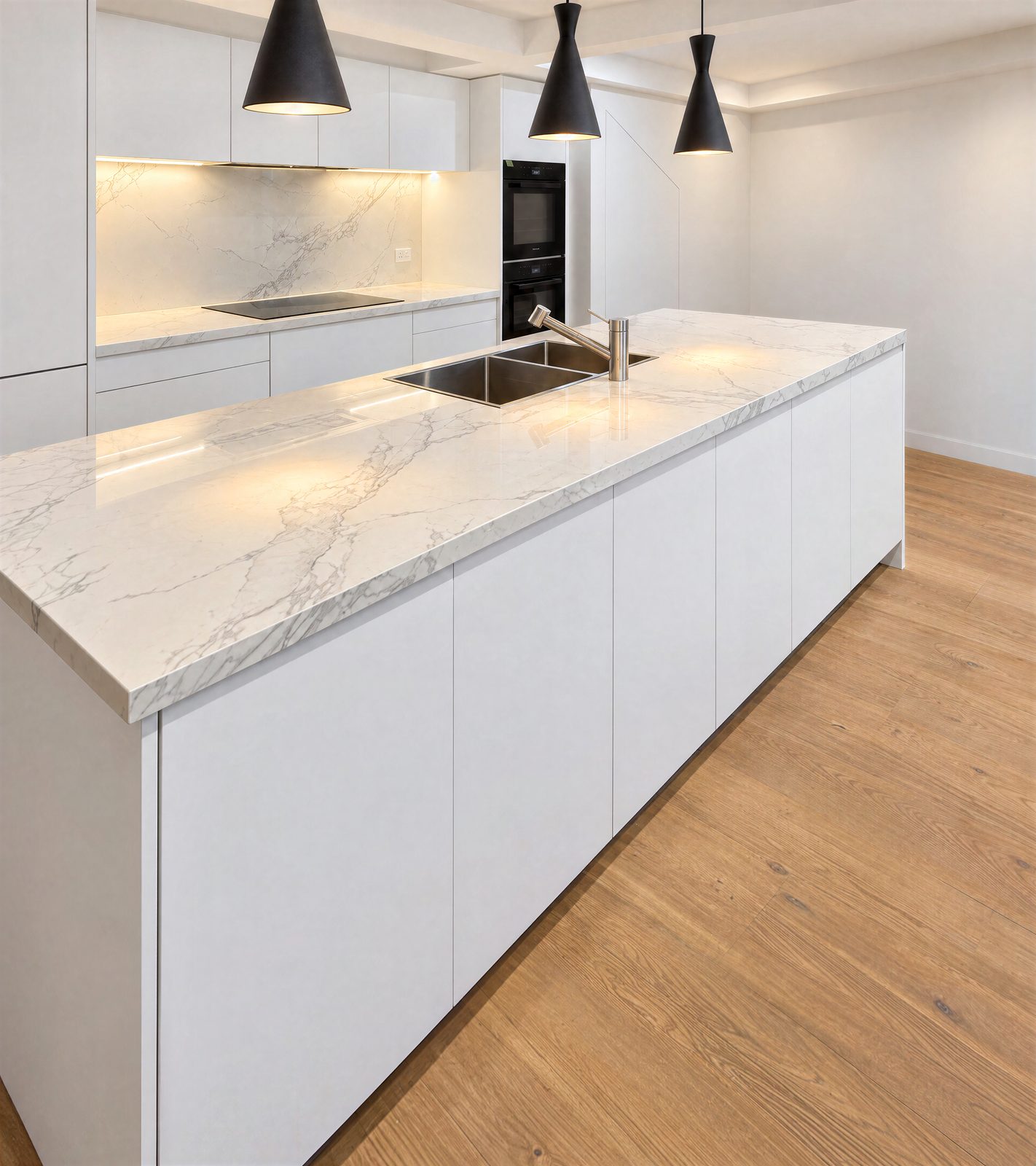 White handle-free kitchen with a marble-look island