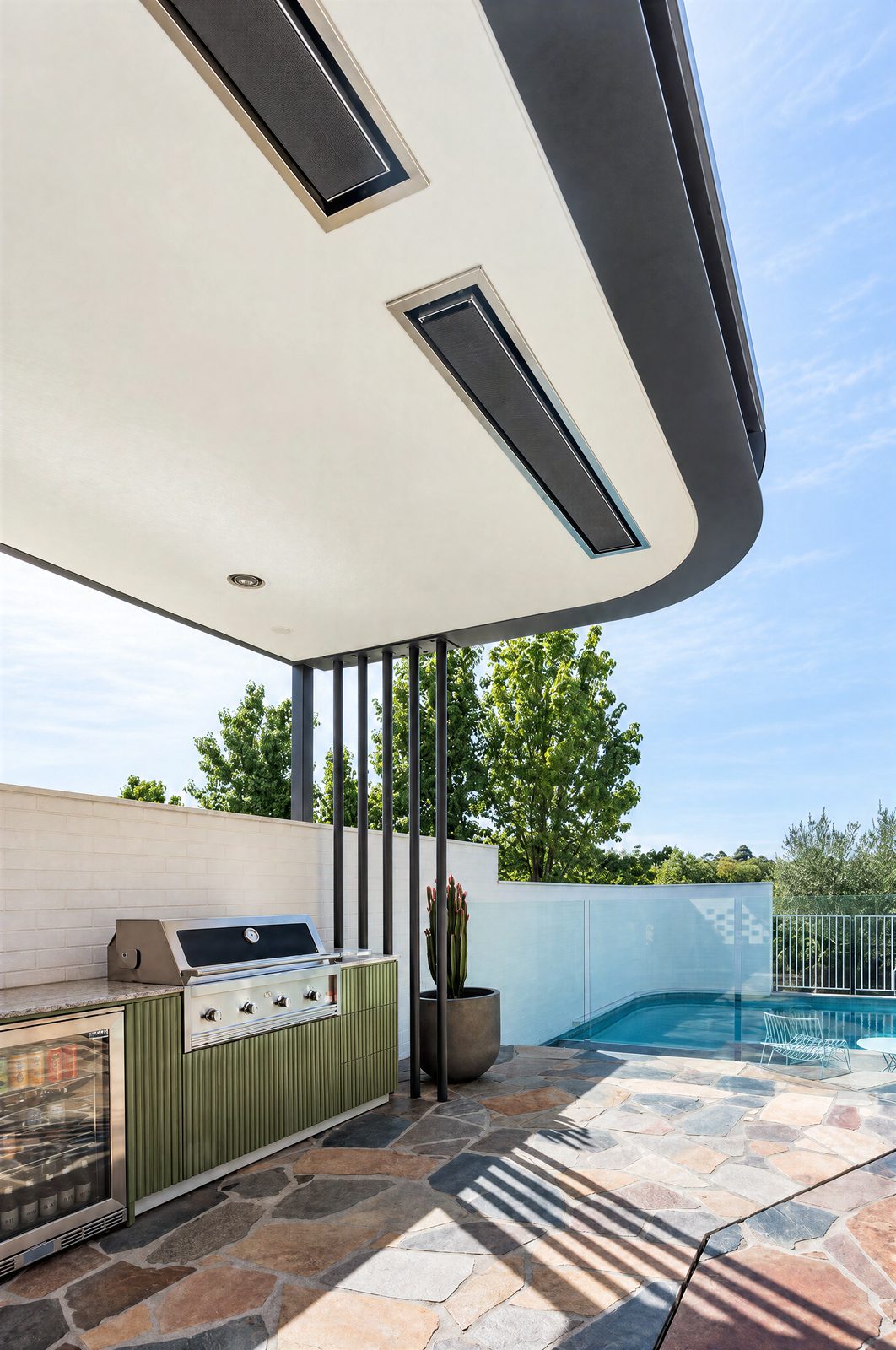 Built-in barbecue and drinks fridge in olive fluted outdoor cabinetry